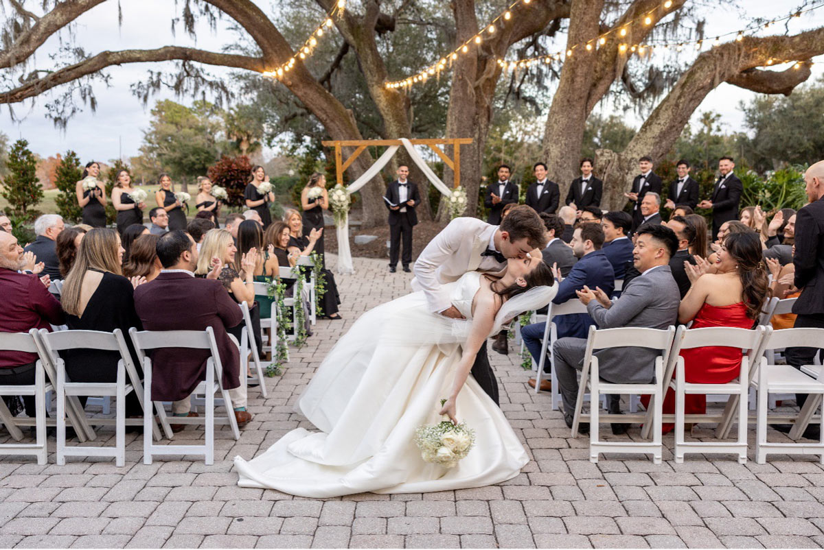 Groom-kissing-the-bride-at-the-end-of-the-aisle-after-wedding
