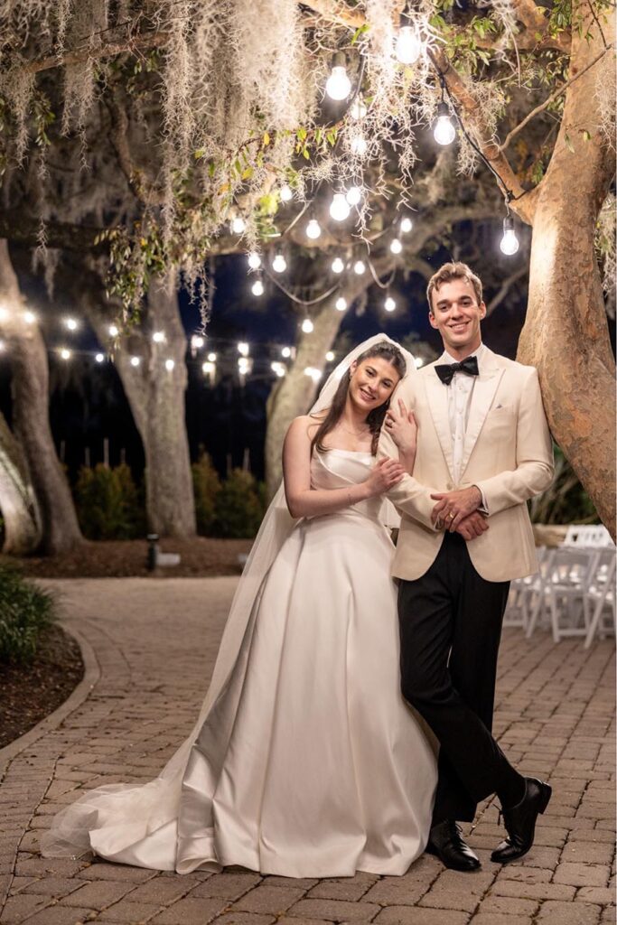 Emily and Jack posing under the market lights by the big oak tree at Historic Dubsdread