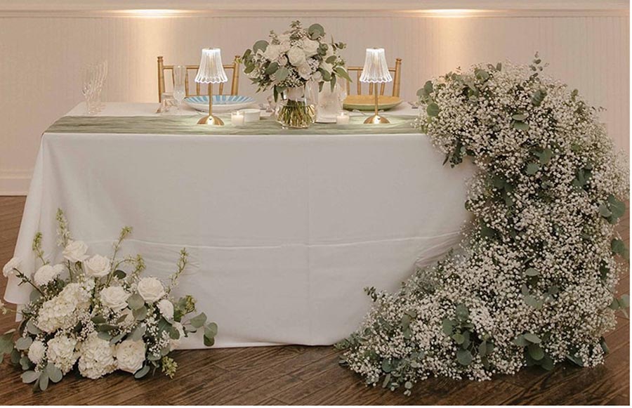 - 06 wedding reception table for the bride and groom decorated with white roses and babys breath wreath