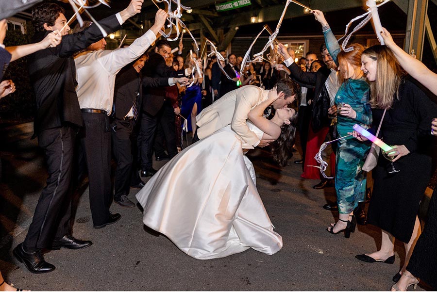 Groom kissing the bride as they leave the wedding reception