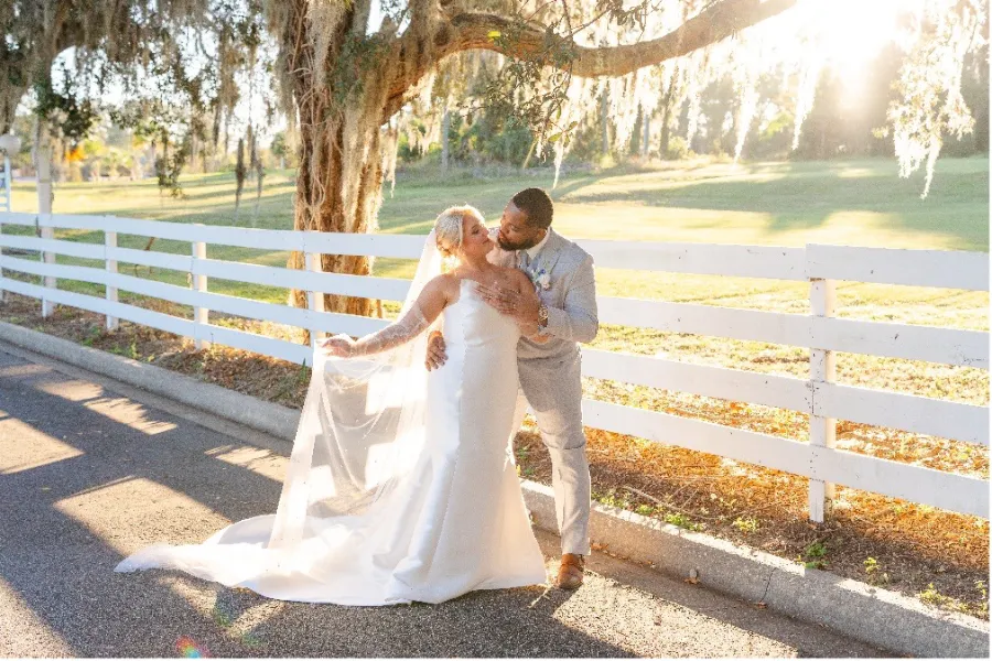 Bride and Groom kissing by the fence of the Highland Manor in Apopka Florida