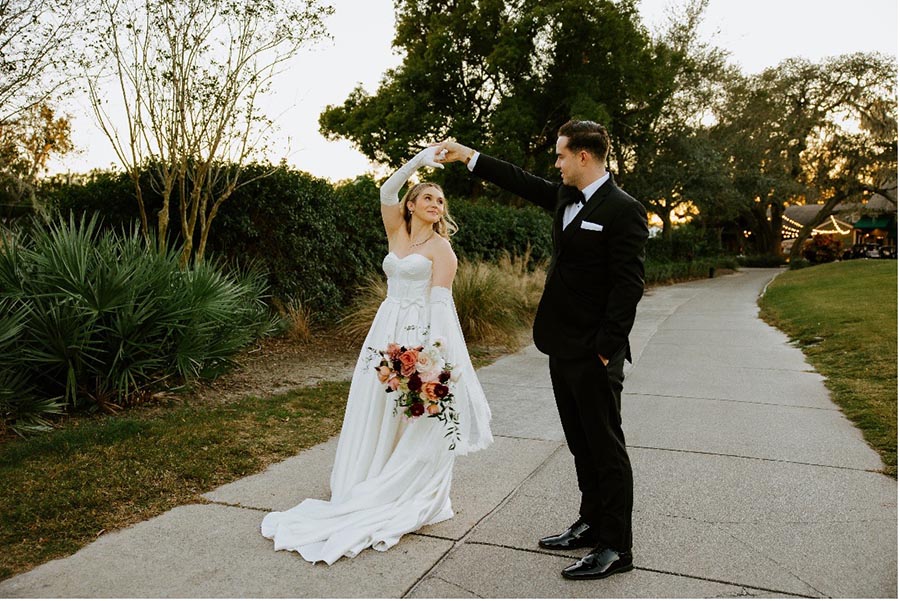 Bride and groom dancing on outdoor path
