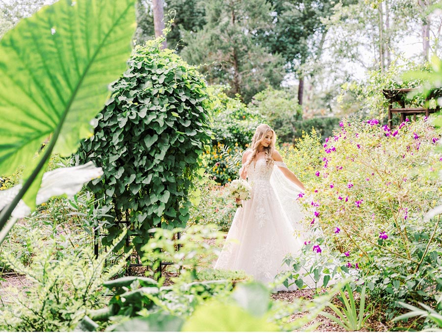Bride posing by flowers in the garden in Winter Park Florida
