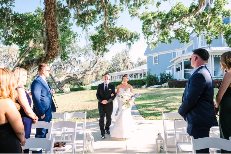 Bride walking down the aisle under the large oak tree at the Highland Manor Florida