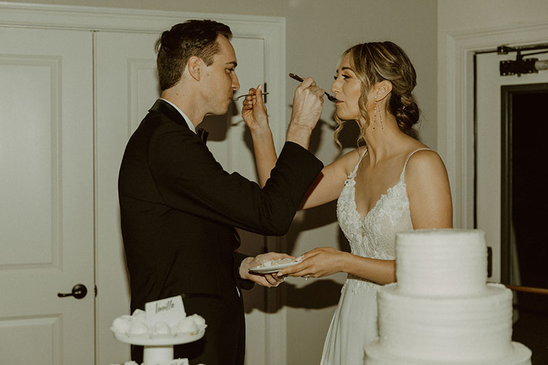 Bride and Groom feeding each other wedding cake