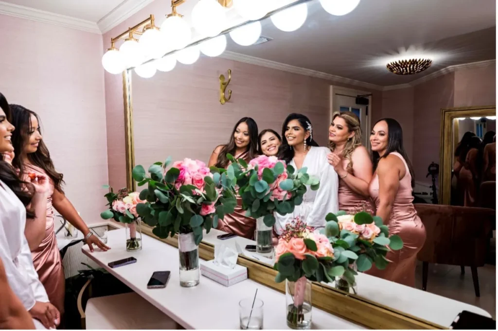 bride and bridesmaids looking into the large mirror