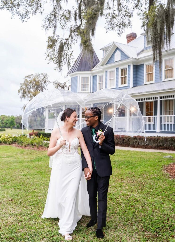 bride-and-groom-holding-umbrellas-and-laughing-at-their-outdoor-wedding