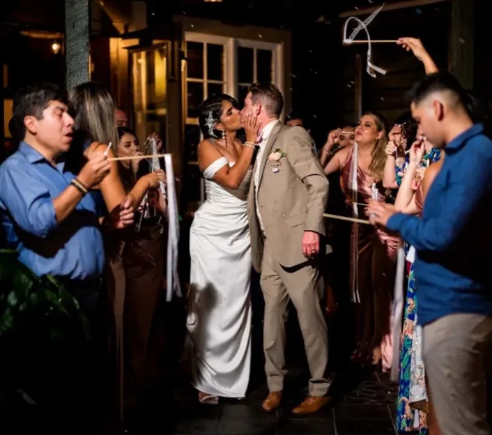 bride and groom kissing surrounded by all their guests