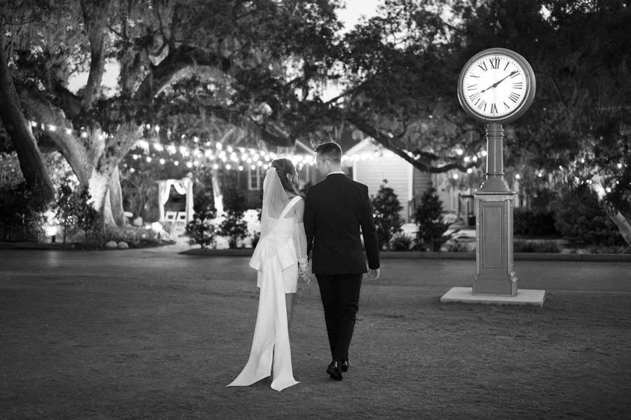 bride-and-groom-walking-across-lawn-at-dusk