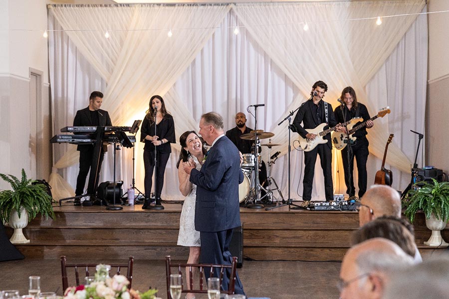 couple dancing in front of a band during wedding reception