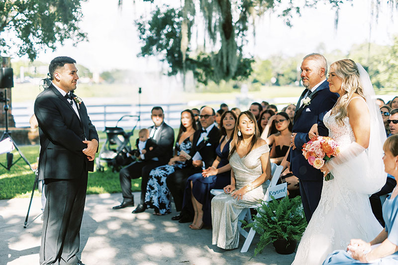 father of the bride walking her down the aisle during wedding ceremony