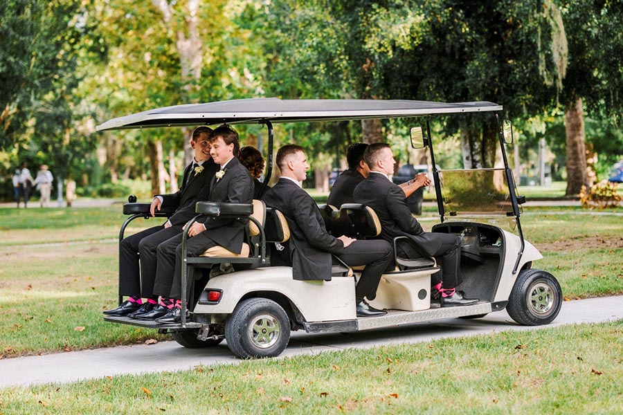 groomsmen in golf cart on the way to the wedding