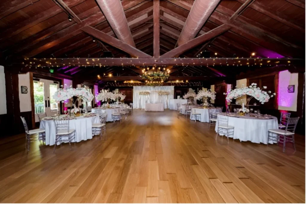 wedding banquet room with tables linen chairs flowers and dance floor